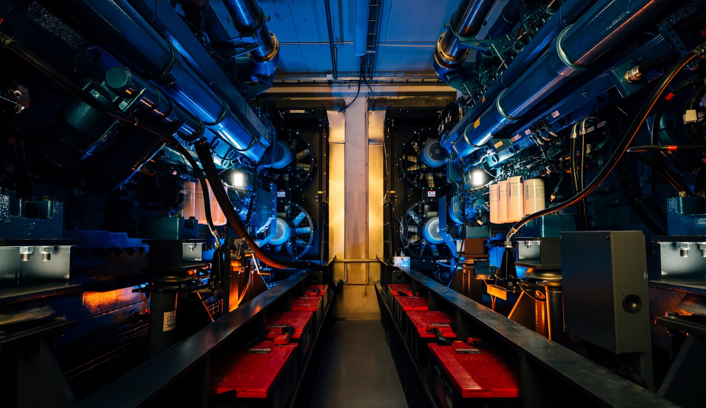 Standby generators in a blue-lit engine room