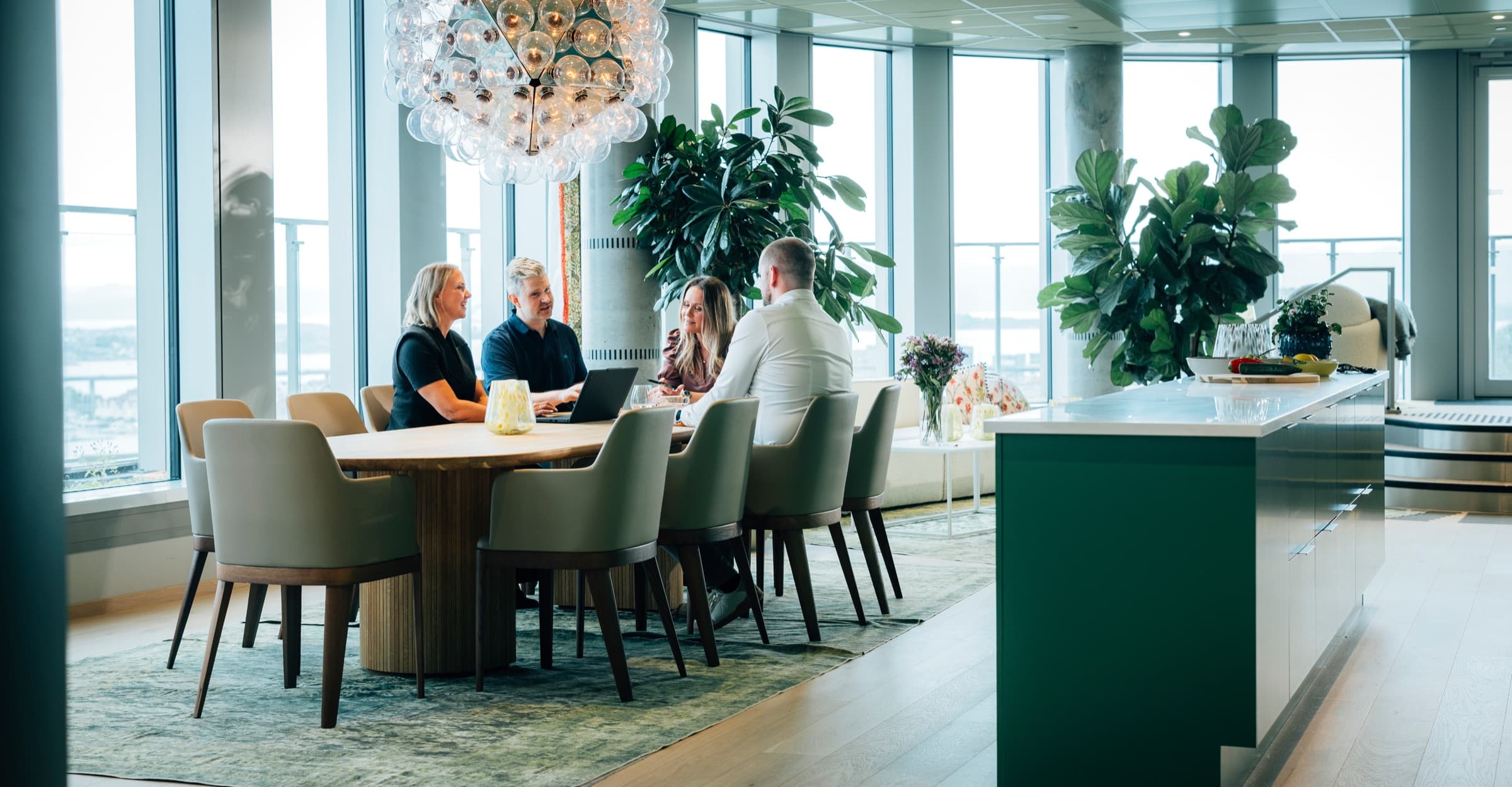 Colleagues meeting around a long table in a bright office