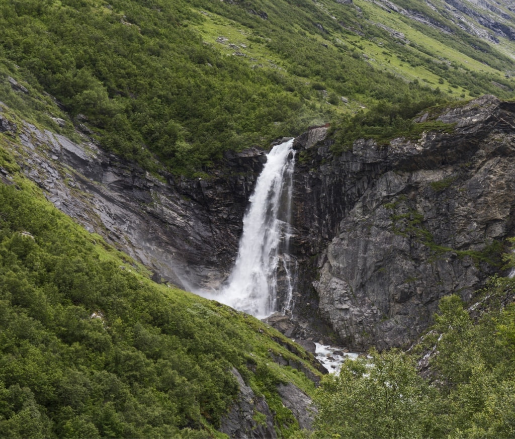 Waterfall running down a green Norwegian mountainside
